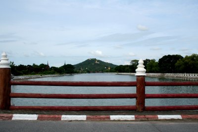 Red fence post with the moat and Mandalay Hill behind it.
