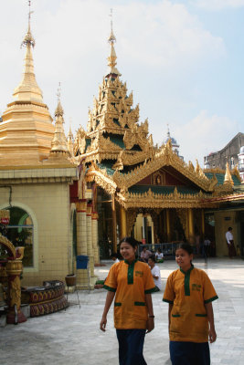 Two women walking by some of the spires at the Sule Pagoda.