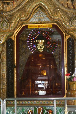 A Buddha statue with an electric halo behind it at the Sule Pagoda.
