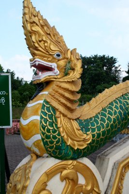 A dragon sculpture going up the railing of the stairs.
