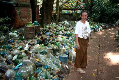 The proprietor of the glass factory standing next to the piles of old glass was to be recycled.