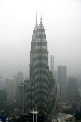 The Petronas Towers from the observation deck on a rainy and foggy day.