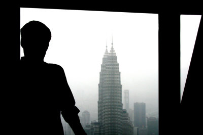 A silhouette of me with a view of the Petronas Towers behind me.