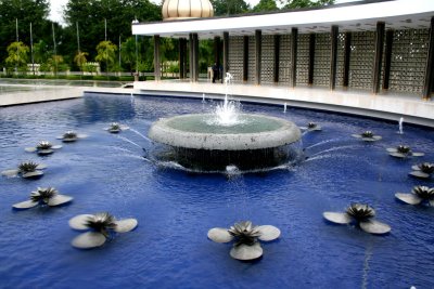 A fountain and pool are in front of the Tugu Negara.