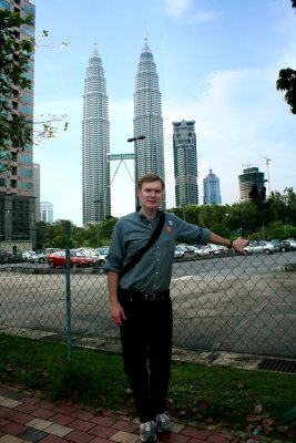A closeup of me standing in front of the Petronas Towers, the world's tallest twin towers.