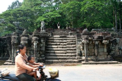 Mother and child whizzing by the Elephant Terrace on a moped (the preferred means of transportation in Angkor Wat).