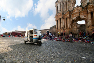 Ruins of the Church of el Carmen with a typical Guatemalan 3-wheeled taxi going by.