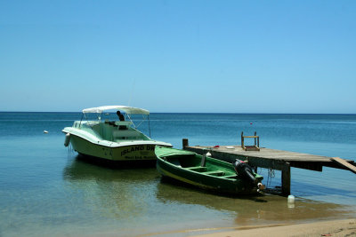 An idyllic shot of some boats docked on the beach at  Roatn's West End.