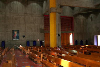 Pews inside the Cathedral of the Immaculate Conception with a painting of Christ in the background.