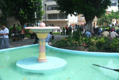 A simple but beautiful fountain in Parque Central with people behind it.