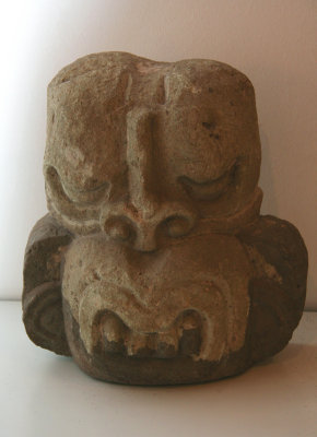 A primitive stone carving of an animal head.