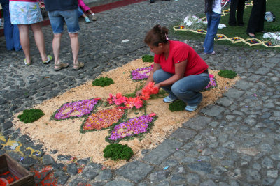 This woman was working on a smaller carpet made of sawdust and flowers.