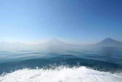 The white wake of the boat with mountains in the background.