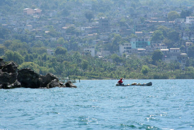 View of the town of Santiago with a man in a canoe in the foreground.