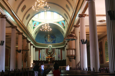 The interior of the cathedral is adorned with a small dome and stained glass windows.
