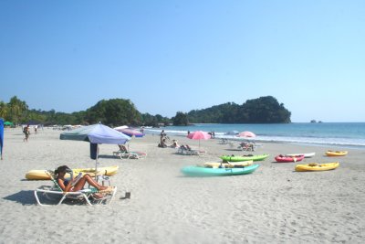 A typical sunny day with sun worshippers and boats on the Manuel Antonio beach.