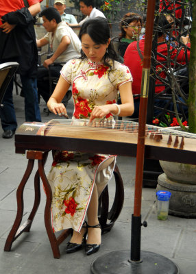 Chengdu playing the ŒÃâ¶ (Guzheng?) at a cafe
