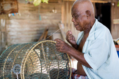 Senior citizen repairing bird cage