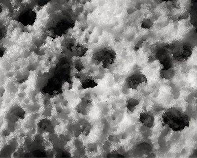 patterns in snow created by drops of melting ice