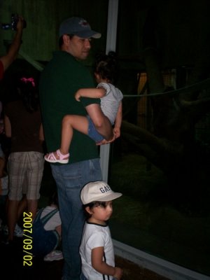 Daddyis holding the girls at the Reptile house