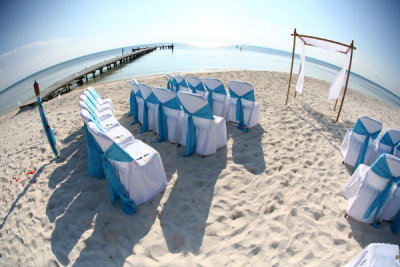 With white covered chairs with aqua sashes and the bamboo/fabric altar structure. Photo by Sol Tamargo, www.soltamargo.com