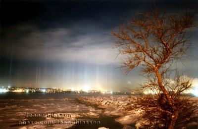 Multicoloured pillars from low level ice crystals reflecting artificial lights.
