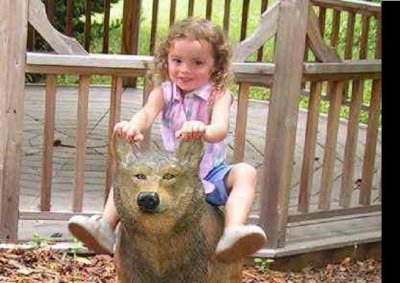 Charity on a wolf toy at the zoo.JPG