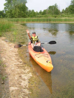 Here's Papa waving from the kayak on our pond in early spring.jpg