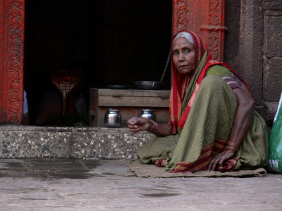 Old lady near small temple
