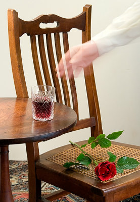 She put her glass on the small table beside the chair and rose.