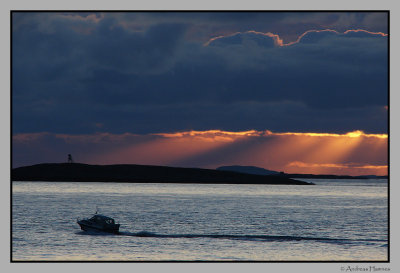 A cabin cruiser passing by Flotra lighthouse