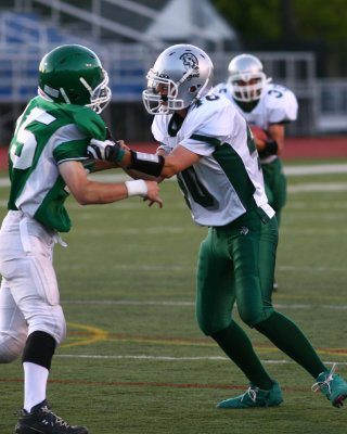 Newfield's Josh Wager punts while Seton's Andrew Tripicco is being held