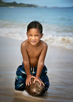 Hawaiian boy playing with coconut