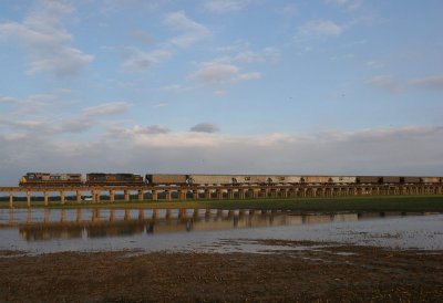 NB grain train G207 reflects in wind blown backwater along the Ohio River viaduct