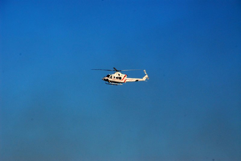 Dubai police helicopter passing behind the smoke plume