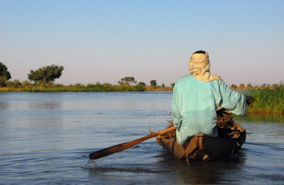 Man paddling a pirogue on the Niger River, near Ayorou