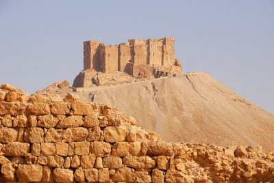 The Arab Citadel rising behind ruins of the defensive wall of Diocletians Camp, Palmyra