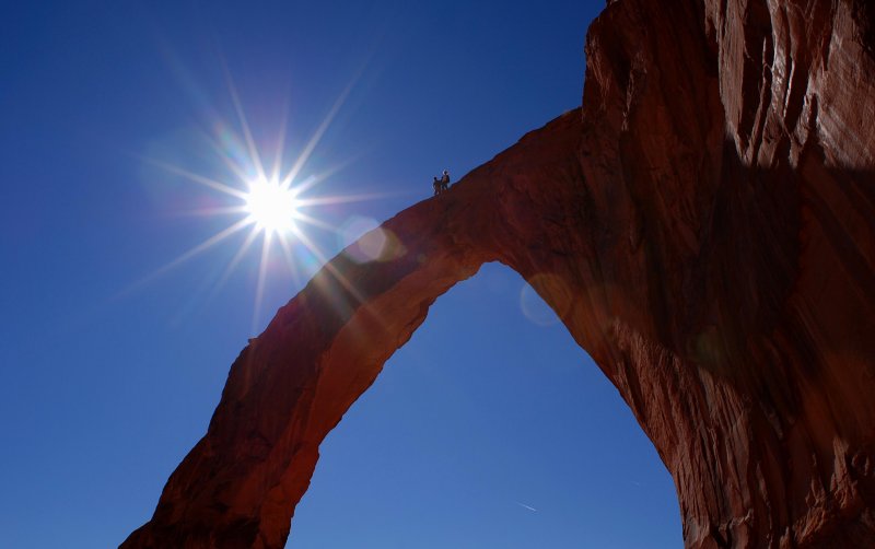 Two college students stand atop Corona Arch