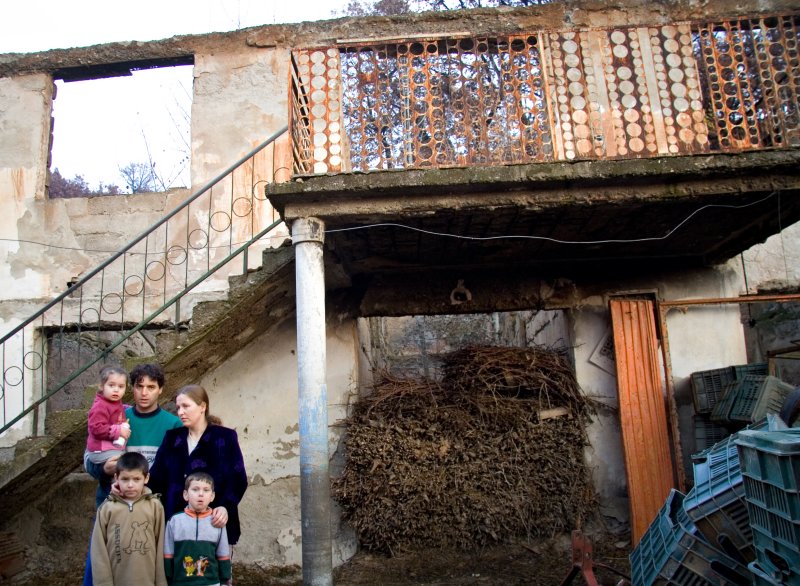 les Raba pausent devant leur maison detruite pdt la guerre