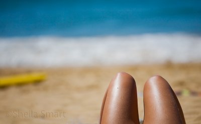 Legs of sunbaker at beach