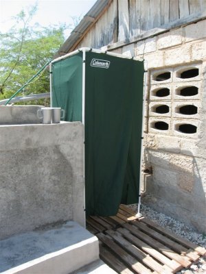 portable shower with rain water collected in the tank beside it