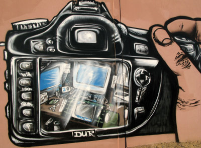 what camera model is this?

(This painting is all about electronic gadgets... the digital camera, the iPod being recharged on a Mac, the cellphone, and a few other gizmos I haven't made out yet. This is an incredibly detailed piece of work.

Dave Hein comment
http://www.pbase.com/heinsite)

