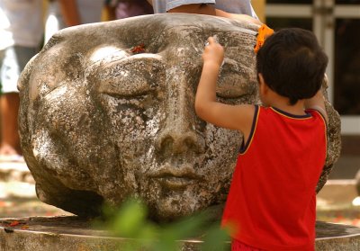 Island Child Plays with Stone Carving