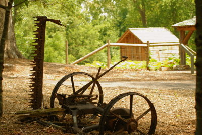 Old farm equipment rests near the farm house.