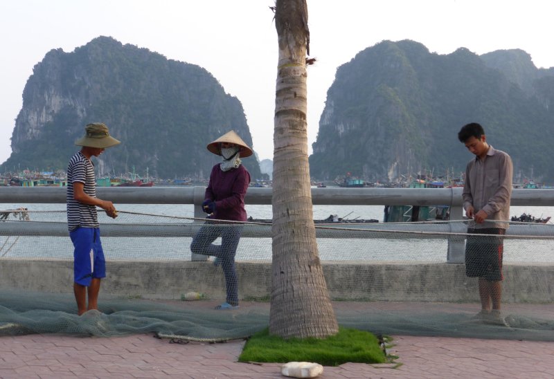 Mending fishing net on the sidewalk or by the seashore?