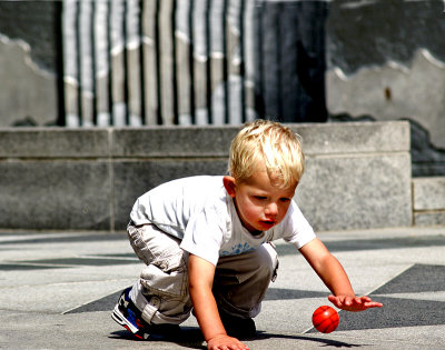 Boy bouncing orange ball