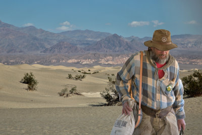 Miner on dunes with bank bag