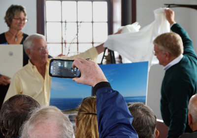 Jim Tyrie (yellow) and Doug McIninch (green)  unveiling the rededicated monument