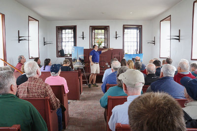 Joe Watts redirects the audience to the outdoor unveiling