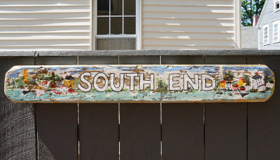 Painted sign board on fence.